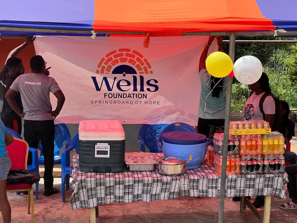 Wells Foundation booth with refreshments and balloons at a community day in Ghana