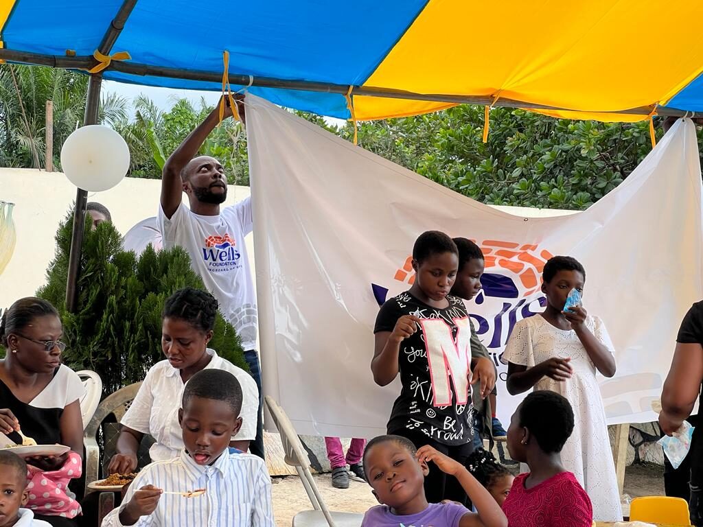 Families gathered under the Wells Foundation banner at a community celebration