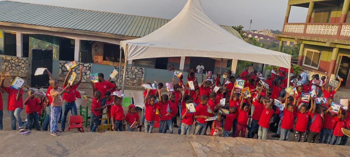 Community members gathered under the tent at a Wells Foundation event in Ghana