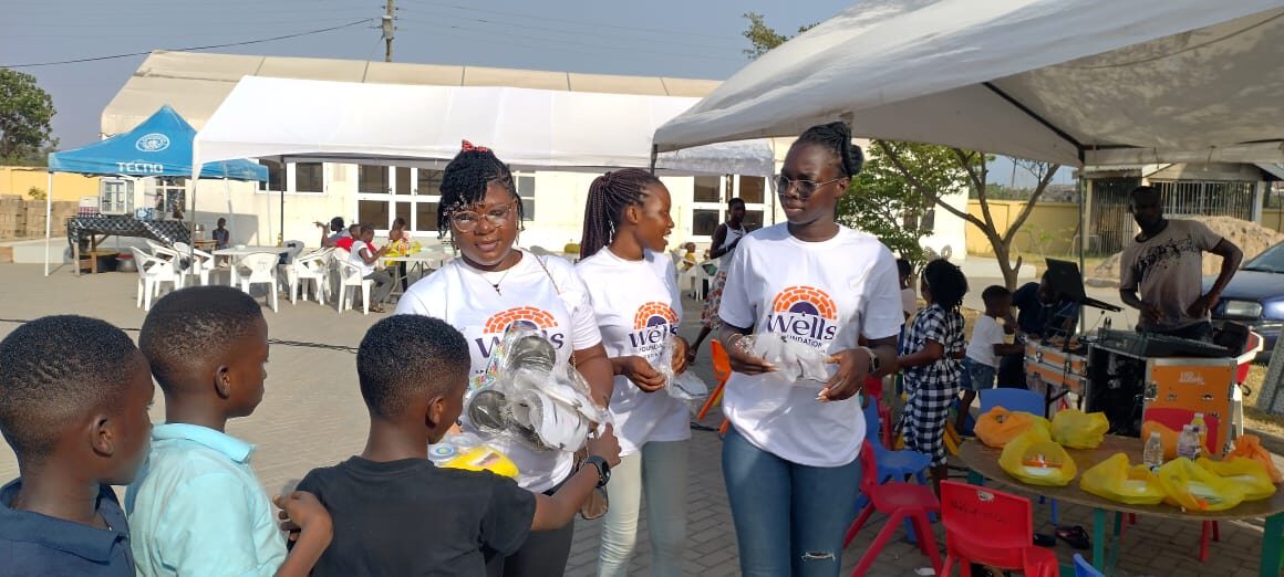 Volunteers serving festive meals to children at a Wells Foundation event