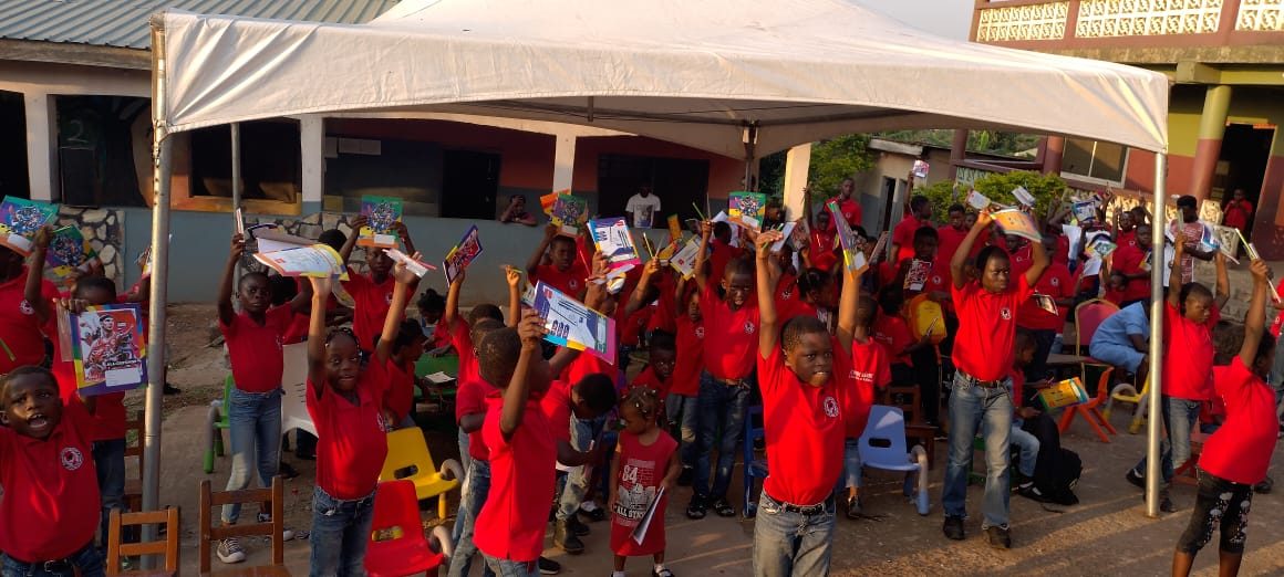 Children holding up gifts donated by the Wells Foundation in Ghana