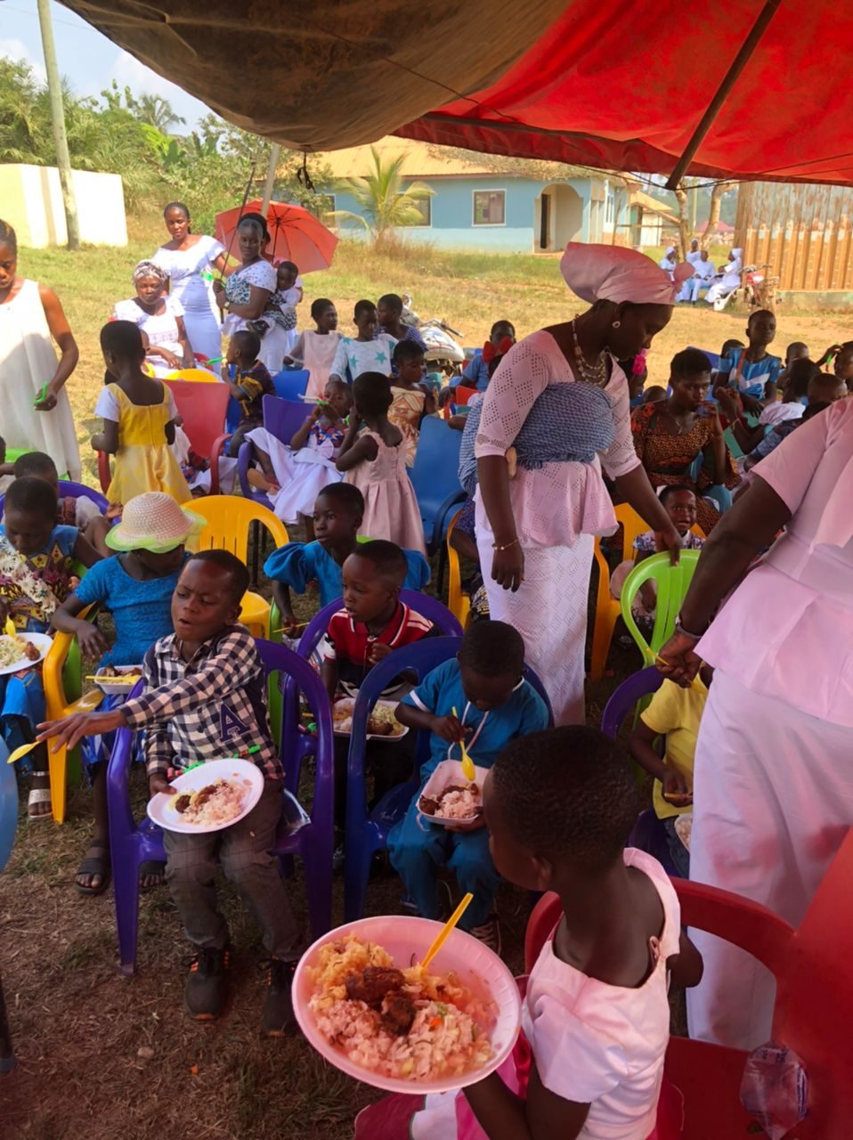 Children enjoying a festive meal at the Wells Foundation orphanage celebration in Ghana